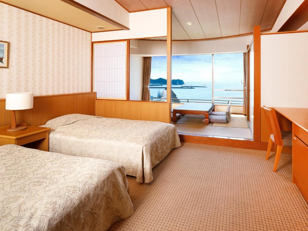 une chambre avec deux lits, un bureau et une fenêtre dans l'établissement Mikazuki Sea-Park Hotel Katsuura, à Katsuura 37 autres photos