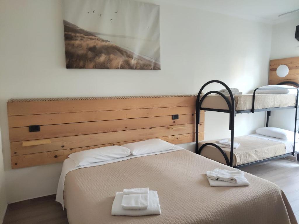 une chambre avec un lit et deux lits superposés dans l'établissement Hotel Garisenda B&B - in Centro a Riccione -, à Riccione