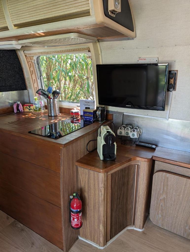 une cuisine dans un camping-car avec une télévision à écran plat dans l'établissement Pooh’s Belle, à Grimaud