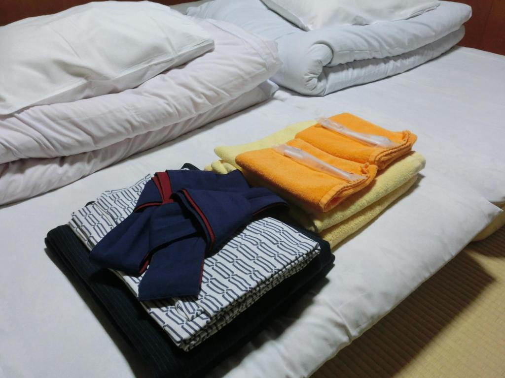 une pile de vêtements pliés sur un lit dans l'établissement Tajimaya, à Nakatsugawa