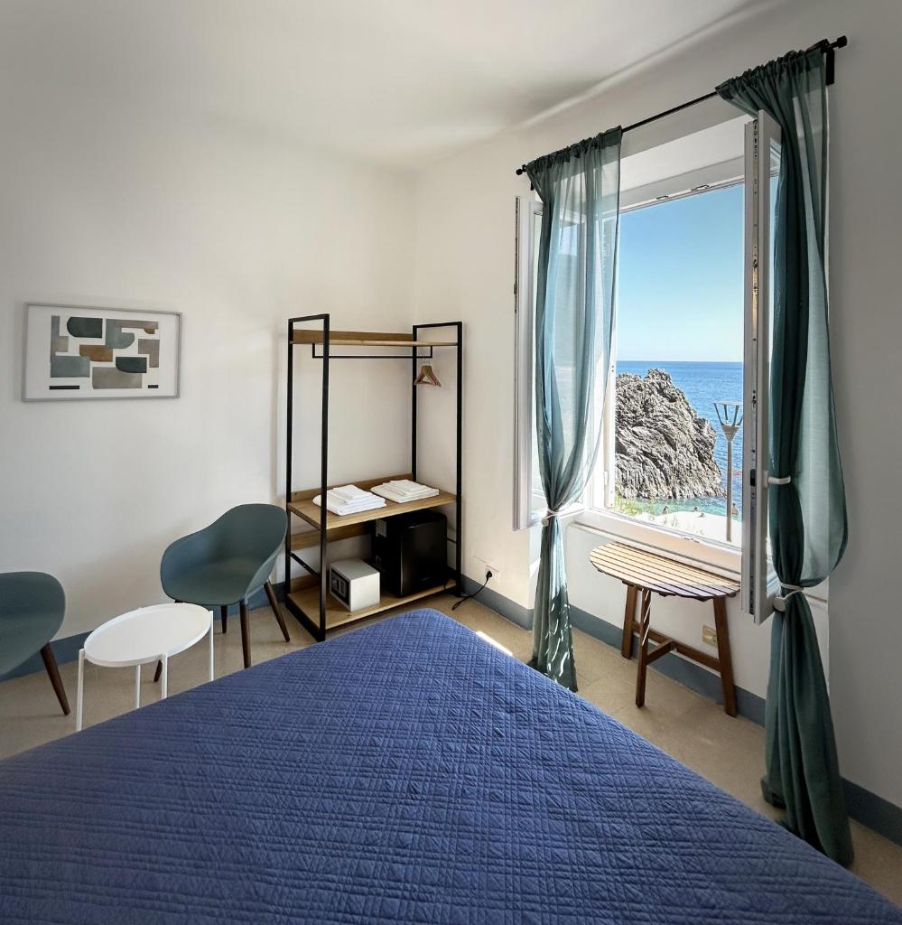 une chambre avec un lit bleu et une fenêtre dans l'établissement Hotel Meublè Agavi, à Monterosso al Mare