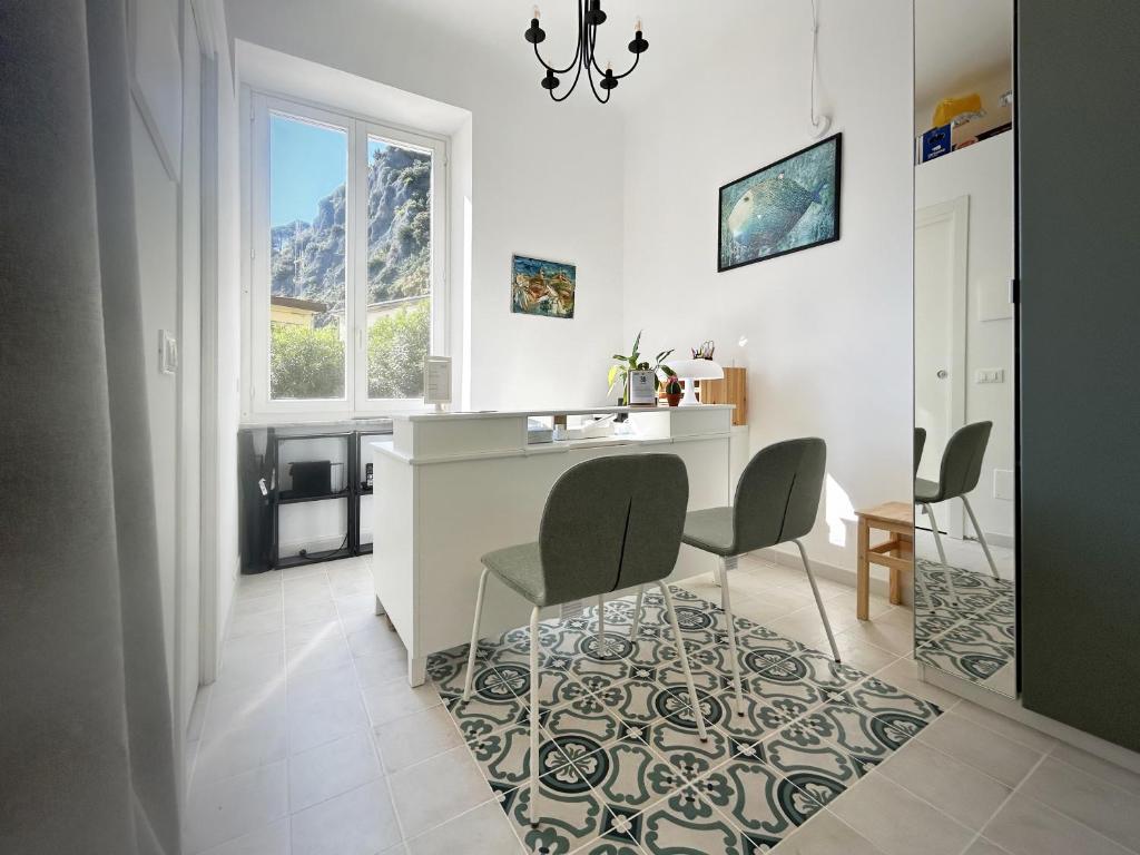 une cuisine avec deux chaises et une table et une fenêtre dans l'établissement Hotel Meublè Agavi, à Monterosso al Mare