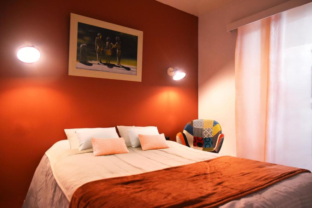 - une chambre avec un lit aux murs orange dans l'établissement Grande Maison Familiale Premium Super Calme - Piscine - Jacuzzi - Salle de Jeux - Idéalement Située - Gd Jardin Sans aucun vis à vis, à Sauzet