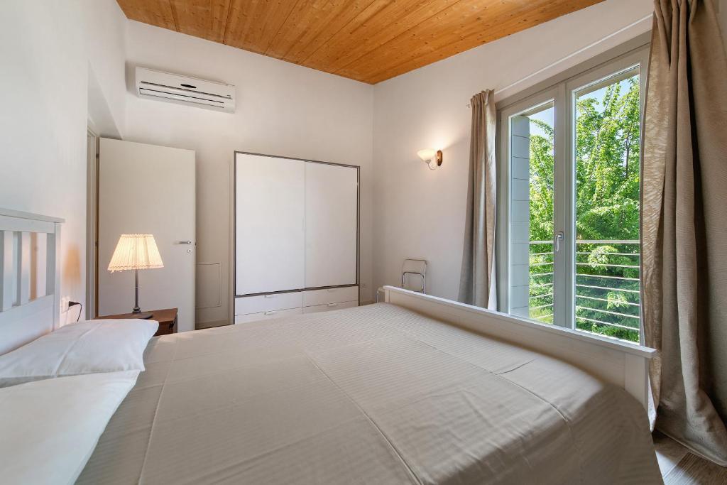 une chambre avec un grand lit et une fenêtre dans l'établissement Le Golfette Ville al Golf 1, à Manerba del Garda