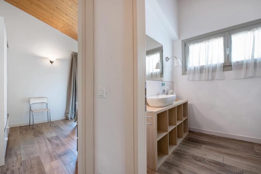 une salle de bain blanche avec un lavabo et un miroir dans l'établissement Le Golfette Ville al Golf 1, à Manerba del Garda