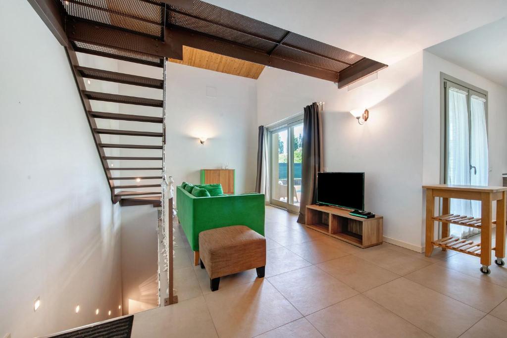 un salon avec un escalier et une télévision dans l'établissement Le Golfette Ville al Golf 1, à Manerba del Garda