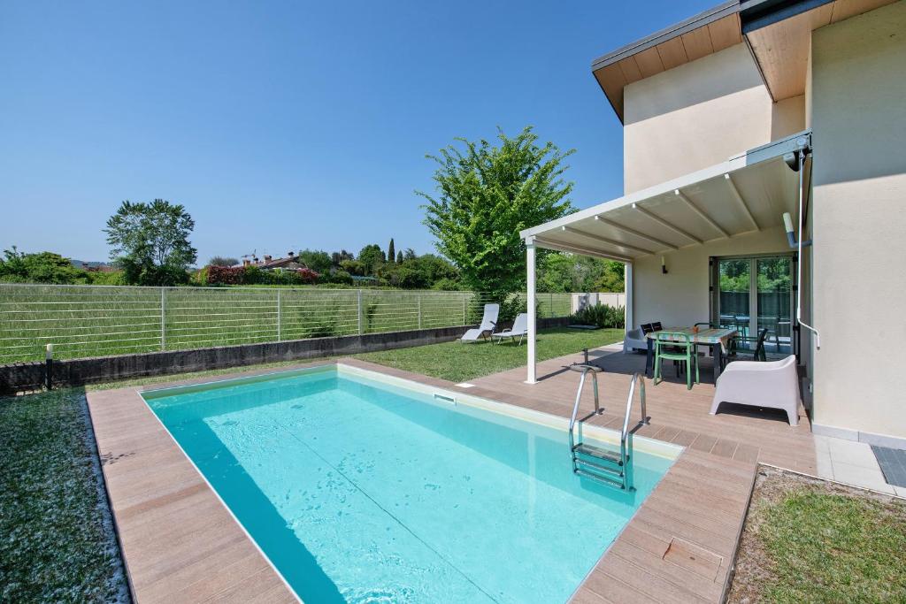 une piscine dans l'arrière-cour d'une maison dans l'établissement Le Golfette Ville al Golf 1, à Manerba del Garda
