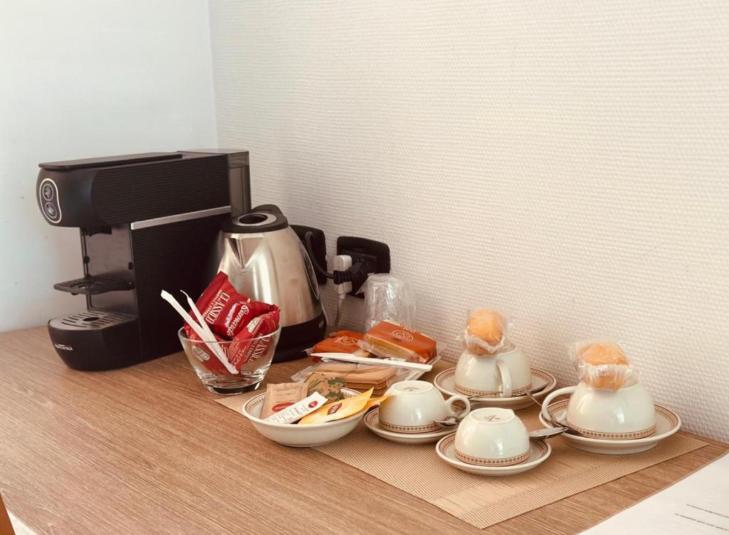 une table avec des assiettes et des tasses ainsi qu'une cafetière dans l'établissement Residence al Palace, à Vasto