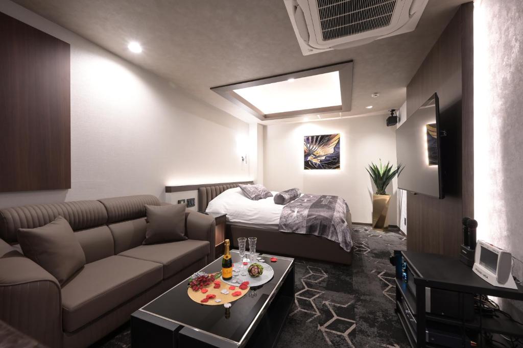 un salon avec un canapé et un lit dans l'établissement Hotel Victoria Court Aasahikawa-Adult Only, à Asahikawa 10 autres photos