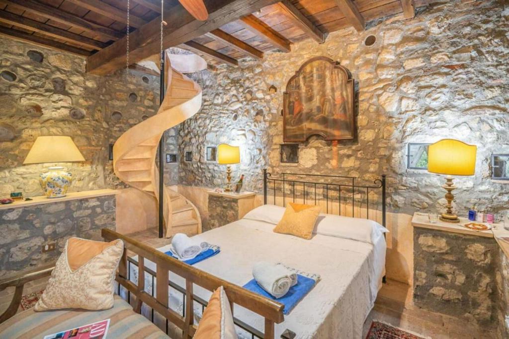 une chambre avec un lit dans un mur de pierre dans l'établissement Torre Vitagliano Resort, à Castel Viscardo