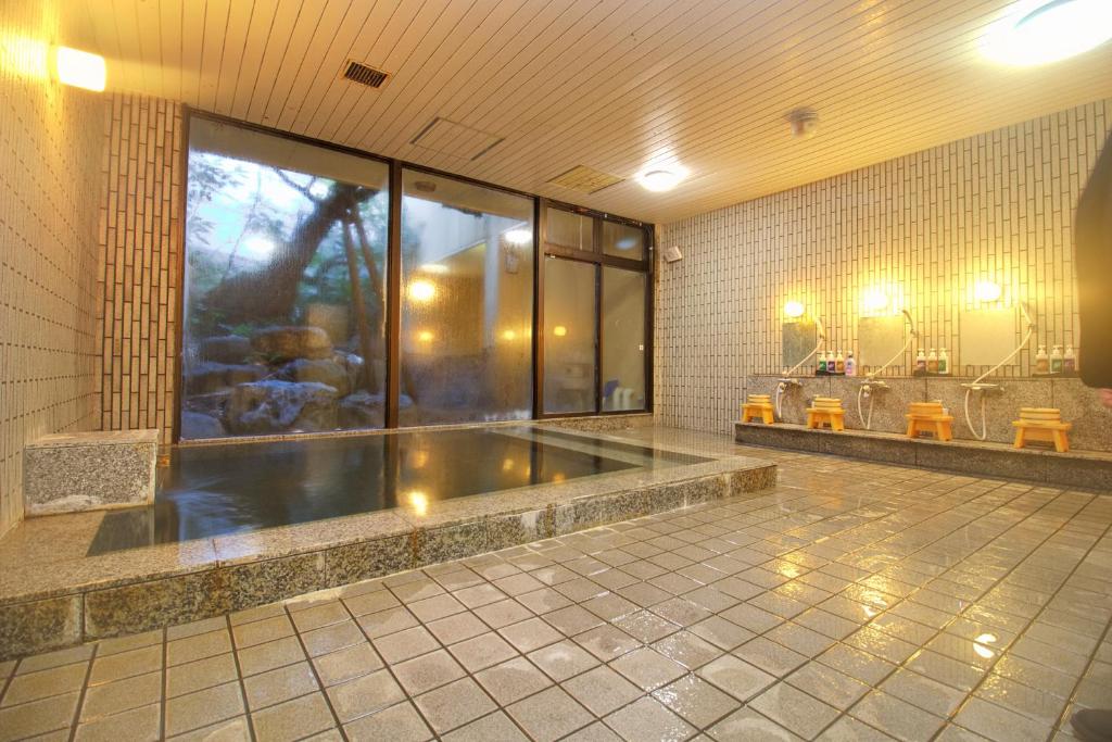 une grande salle de bains avec baignoire dans une chambre dans l'établissement Hotel Kinu, à Nikkō