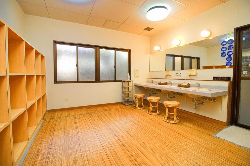 une grande salle de bain avec deux lavabos et deux tabourets dans l'établissement Hotel Kinu, à Nikkō