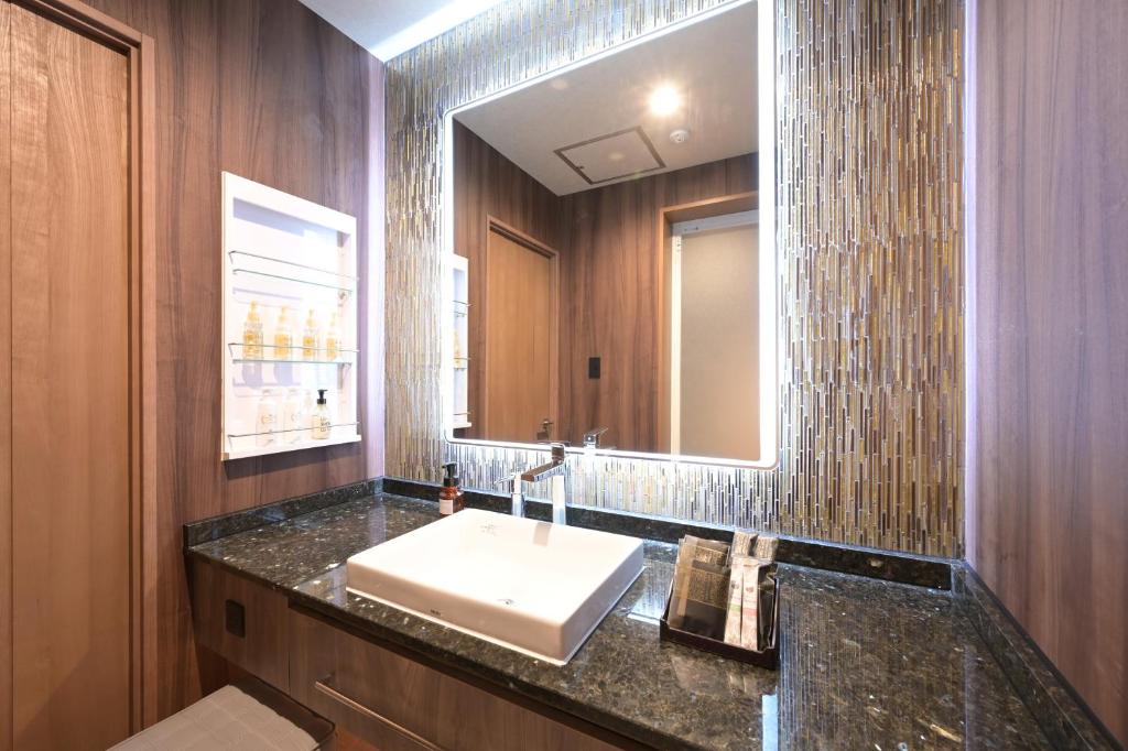 une salle de bain avec un lavabo et un miroir dans l'établissement Hotel Victoria Court Aasahikawa-Adult Only, à Asahikawa