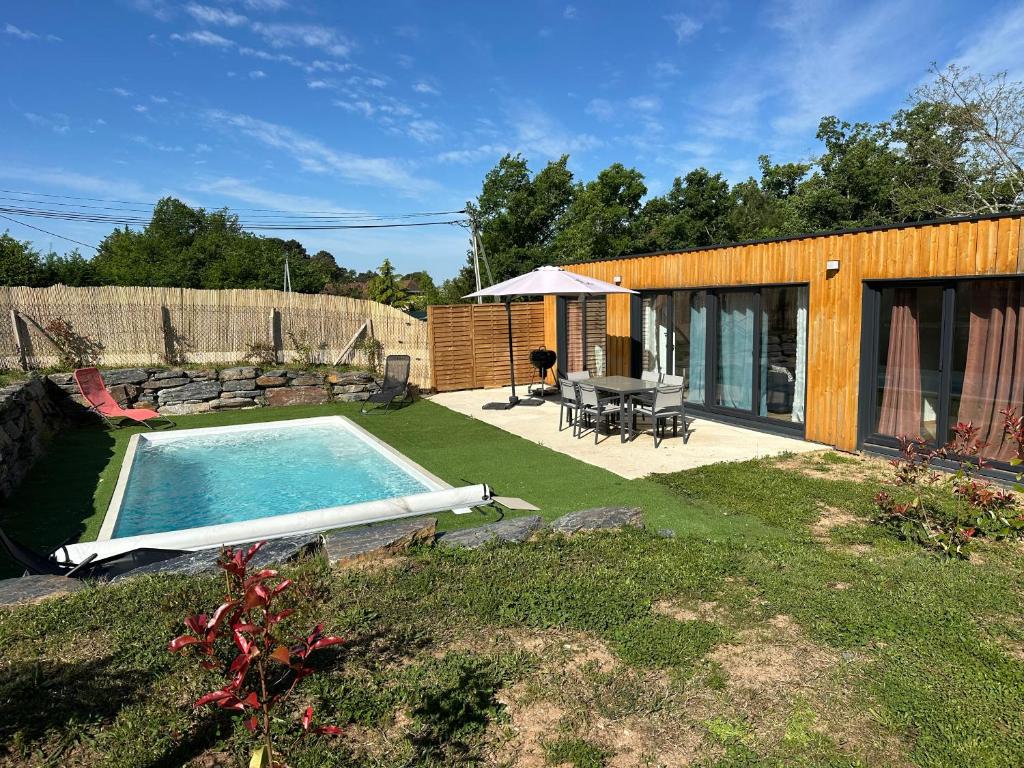 une cour avec une piscine, une table et une terrasse dans l'établissement Les Chalets du Pialou, à Cosnac