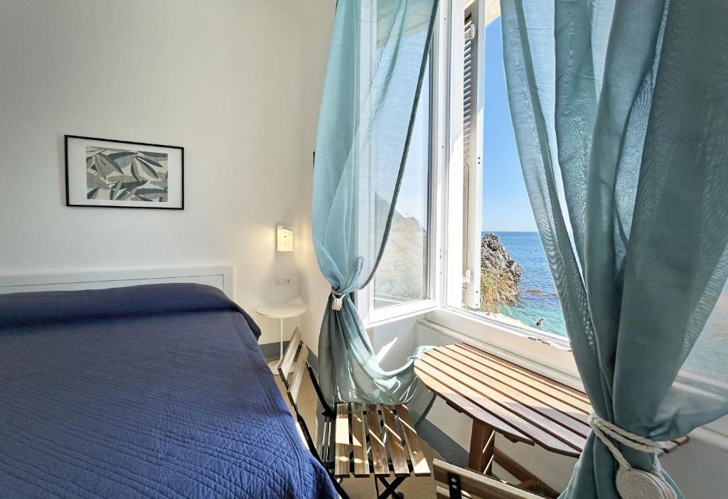 une chambre avec un lit et une fenêtre avec l'océan dans l'établissement Hotel Meublè Agavi, à Monterosso al Mare