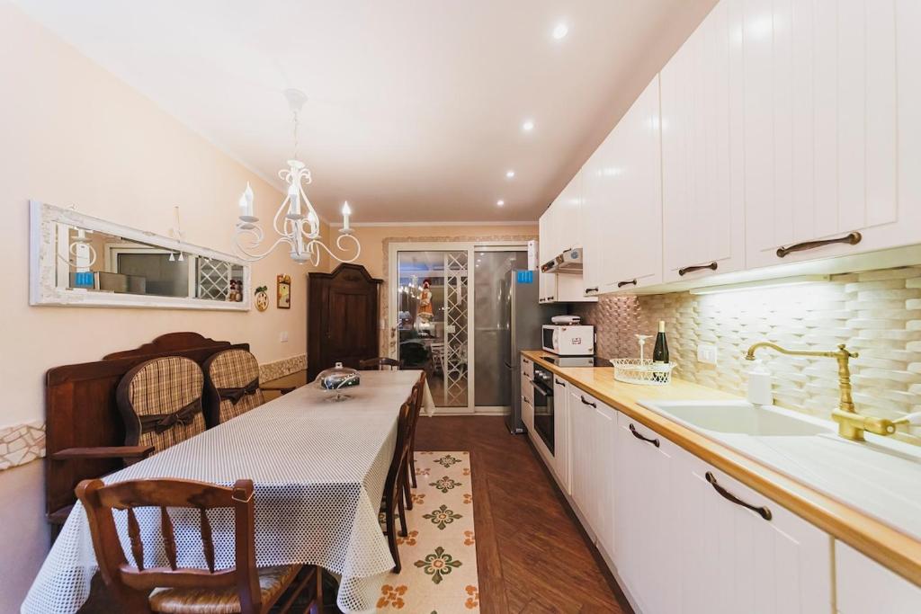 une cuisine avec une table, un évier et un comptoir dans l'établissement Villa ElSi, Where Relaxation and Elegance Meet, à Valenzano
