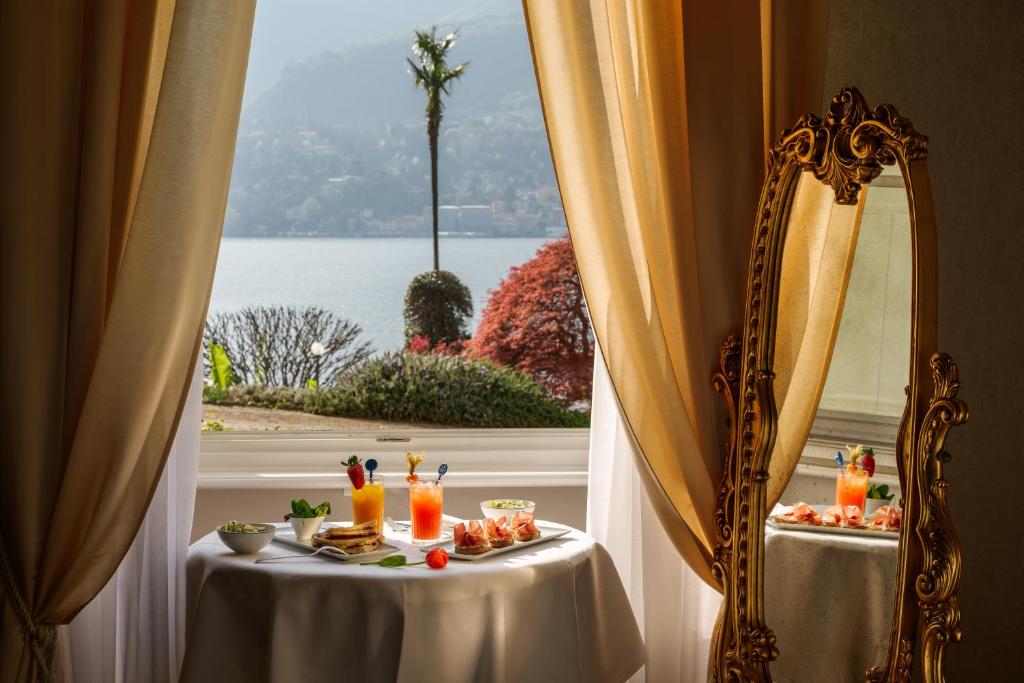une table avec des boissons devant un miroir dans l'établissement Grand Hotel Villa Serbelloni - A Legendary Hotel, à Bellagio