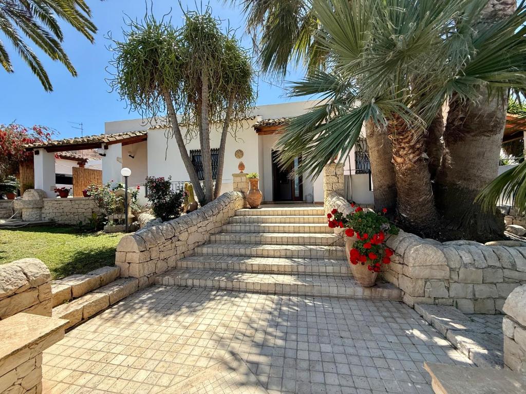 un chemin en pierre menant à une maison avec des palmiers dans l'établissement Villa Urùca, à Cava dʼAliga