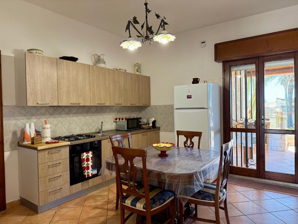 une cuisine avec une table et un réfrigérateur blanc dans l'établissement Villa Urùca, à Cava dʼAliga