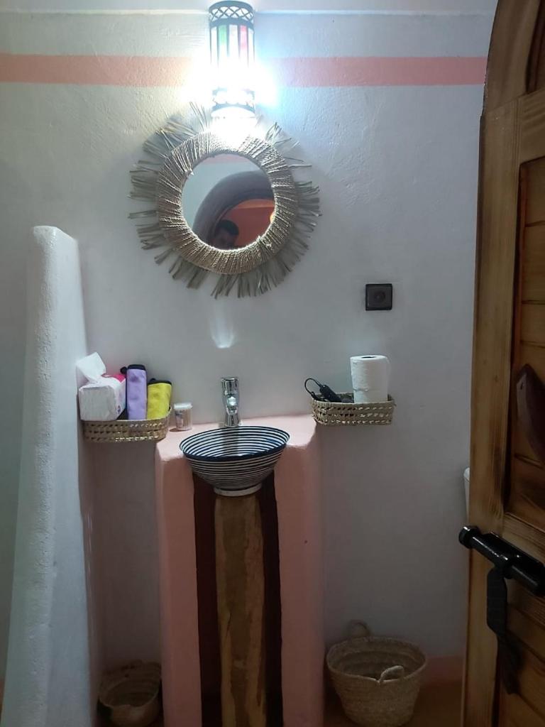 une salle de bain avec un lavabo et un miroir au mur dans l'établissement DAR DANI café restaurant, à Boumalne