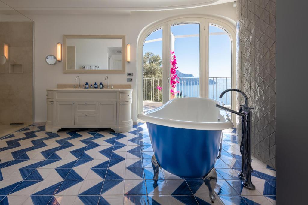 une salle de bain avec une grande baignoire et un lavabo dans l'établissement Borgo Santandrea, à Amalfi