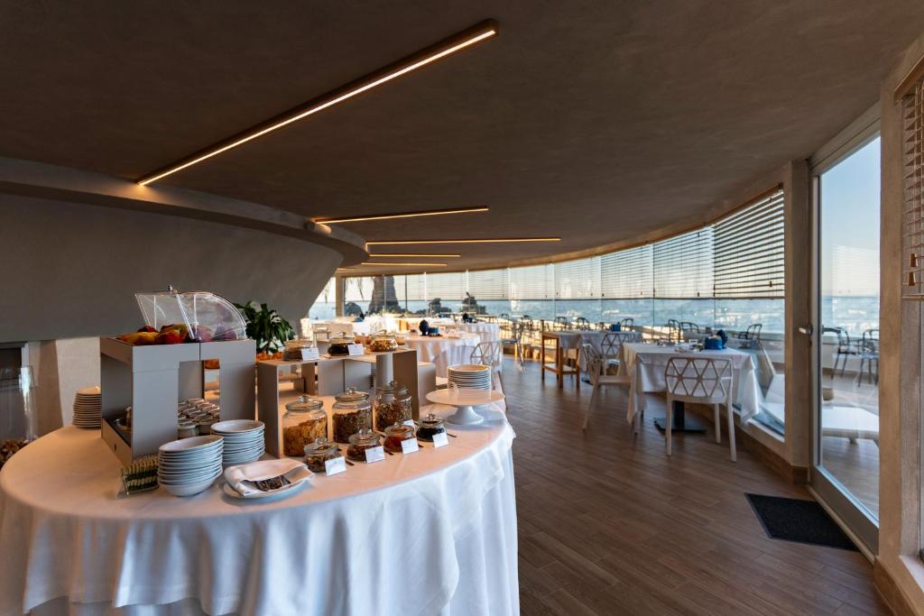 une salle à manger avec une table et de la vaisselle dans l'établissement Grand Hotel Faraglioni, à Aci Trezza