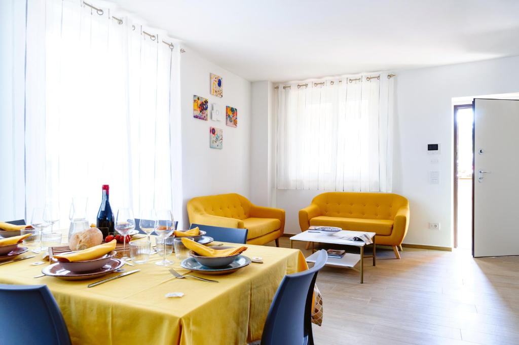 une salle à manger avec une table et des chaises jaunes dans l'établissement Villa Ophite, à Offida