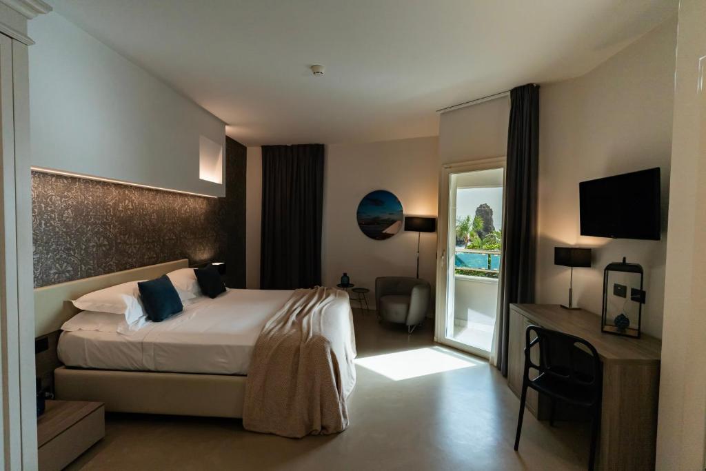 une chambre d'hôtel avec un lit et un balcon dans l'établissement Grand Hotel Faraglioni, à Aci Trezza 65 autres photos