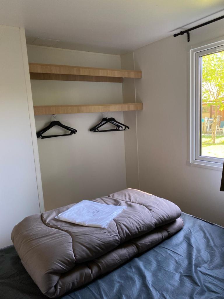 un lit dans une chambre avec une fenêtre dans l'établissement Camping Bois et Toilés, à Peyraud