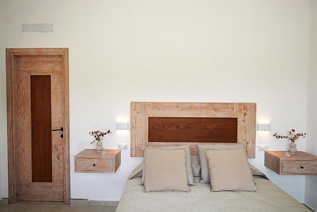 une chambre avec un lit avec une tête de lit en bois dans l'établissement Porto Cervo-Villa La Gjanda, à Abbiadori