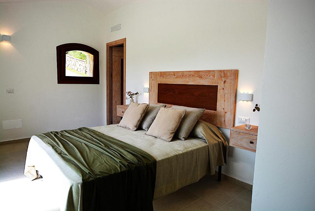 une chambre avec un lit avec une tête de lit en bois dans l'établissement Porto Cervo-Villa La Gjanda, à Abbiadori