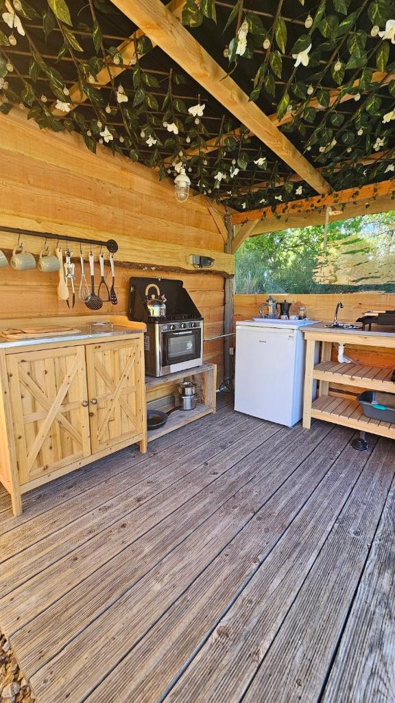 - une cuisine dans une cabane en bois avec une cuisinière dans l'établissement Lotus Belle Tipi at Le Ranch Camping et Glamping, à Madranges