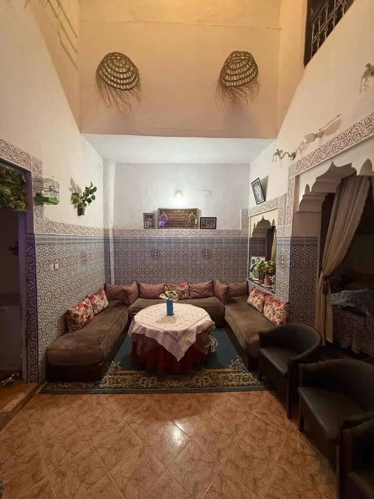 un salon avec un canapé et une table dans l'établissement Riad Elkorchi, à Fès