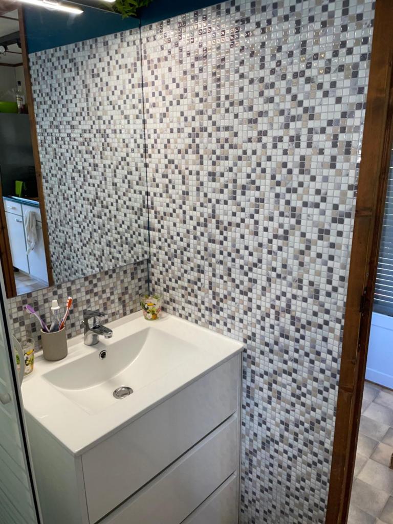 La salle de bains est pourvue d'un lavabo et d'un mur carrelé. dans l'établissement mobile home dans un coin de paradis, à Fréjus