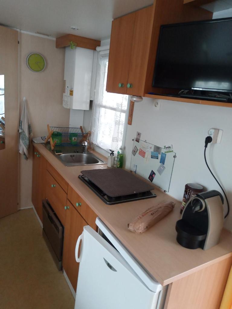 Il comprend une petite cuisine avec un évier et un comptoir. dans l'établissement Camping l'escale, à Agde