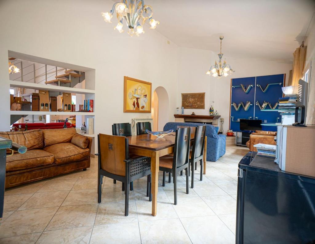 un salon avec une table, des chaises et un canapé dans l'établissement Villa Malvasia with Pool and Garden - Borgo Stays, à Oriolo Romano