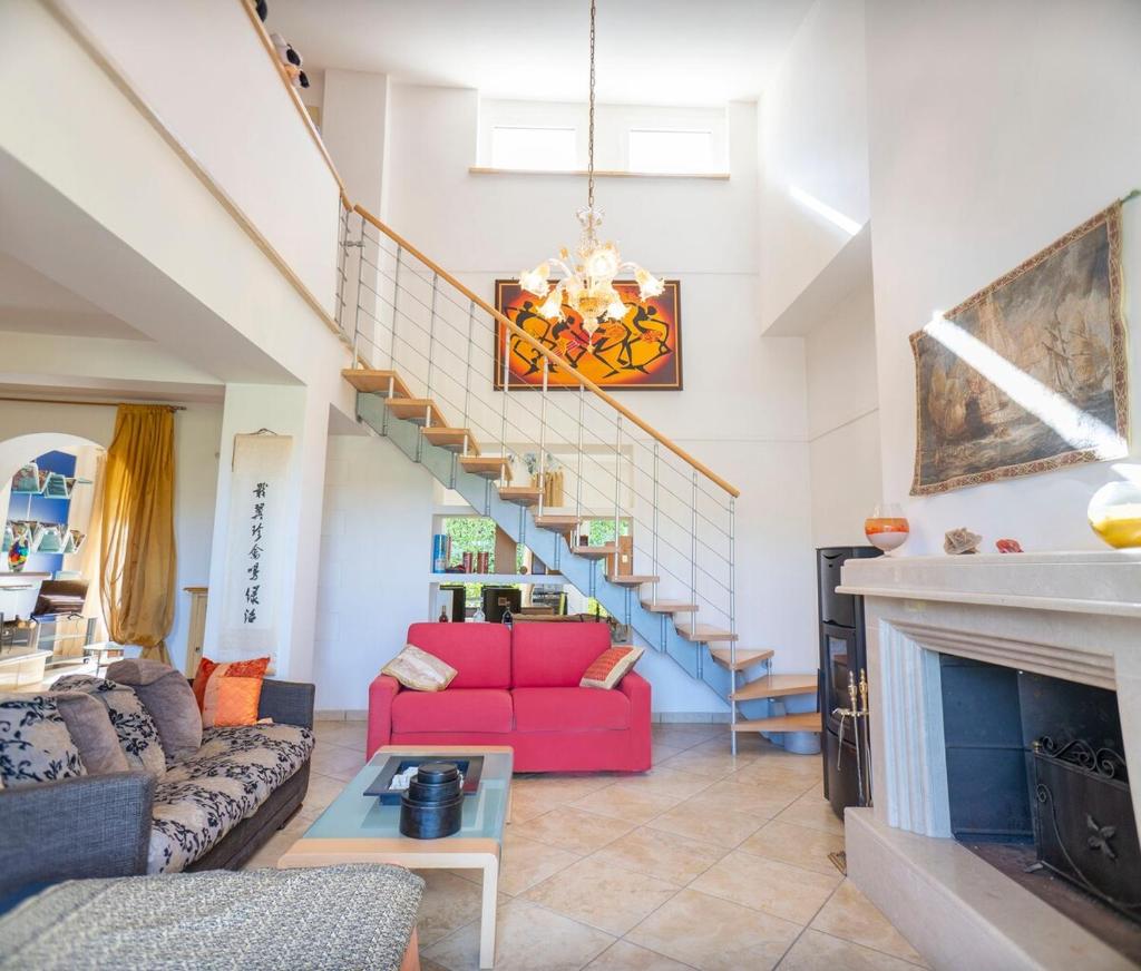 - un salon avec un canapé rouge et un escalier dans l'établissement Villa Malvasia with Pool and Garden - Borgo Stays, à Oriolo Romano