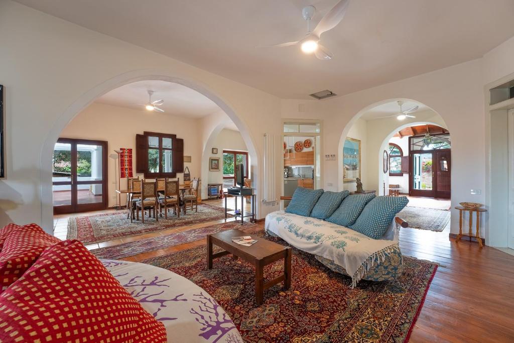 un salon avec un canapé et une table dans l'établissement Historic Villa Giardini, Pool and Private Park, à Capoterra