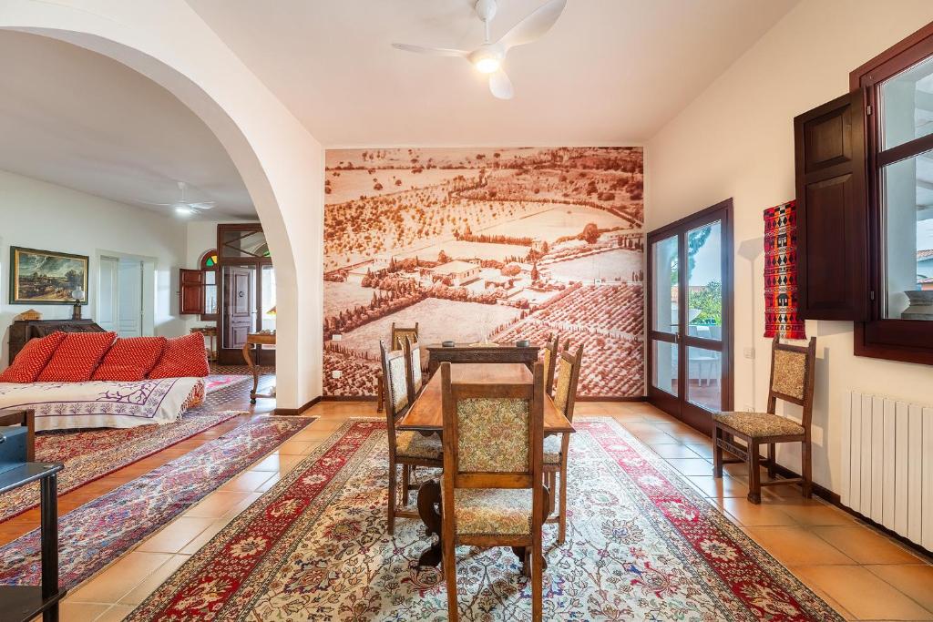 d'un salon avec une table et une peinture murale. dans l'établissement Historic Villa Giardini, Pool and Private Park, à Capoterra