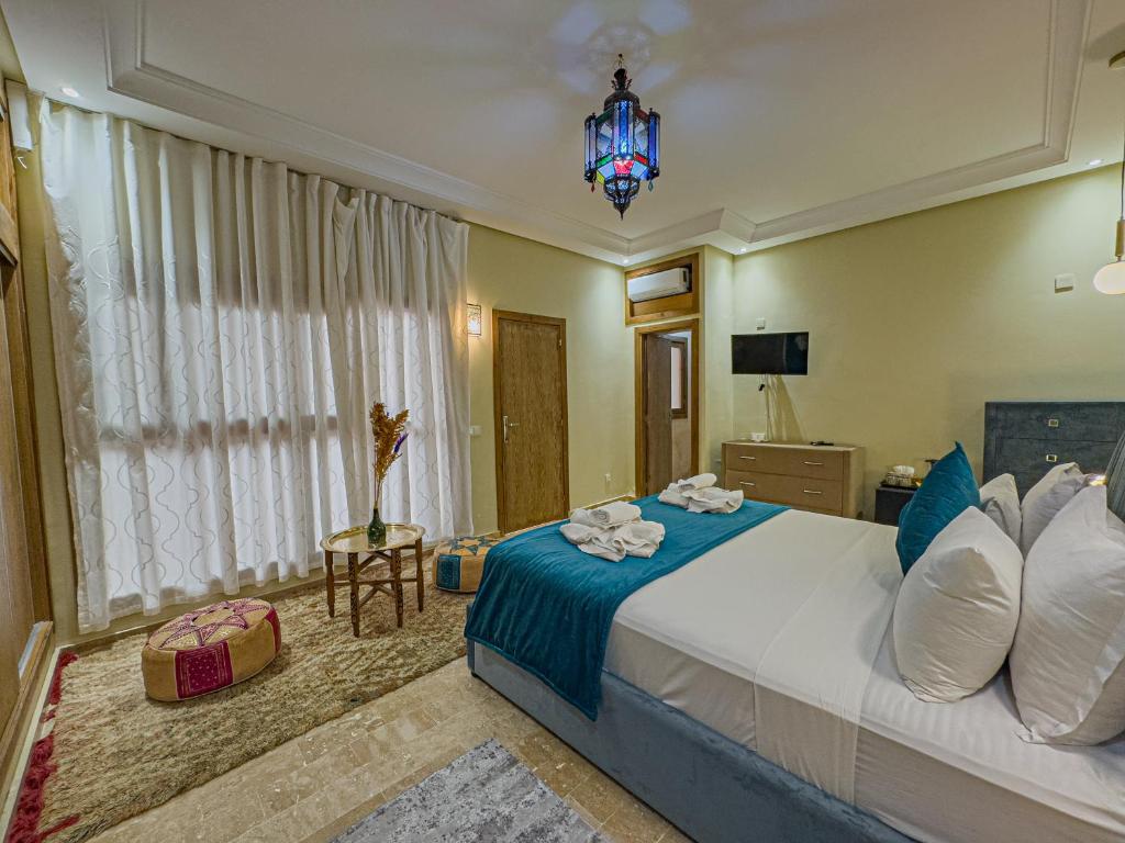 une chambre avec un grand lit et un lustre dans l'établissement Riad Azia, à Marrakech