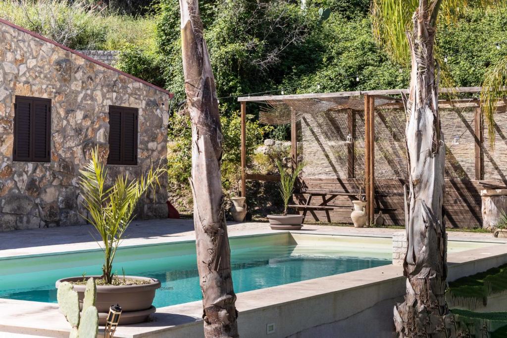- une piscine bordée de 2 palmiers dans l'établissement Rifugio del Sole, à Noto