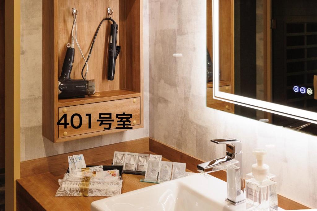 La salle de bains est pourvue d'un lavabo, d'un miroir et d'un téléphone. dans l'établissement Hotel Room, à Miyazaki