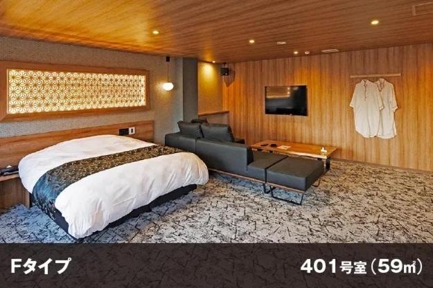 une chambre avec un grand lit et un canapé dans l'établissement Hotel Room, à Miyazaki