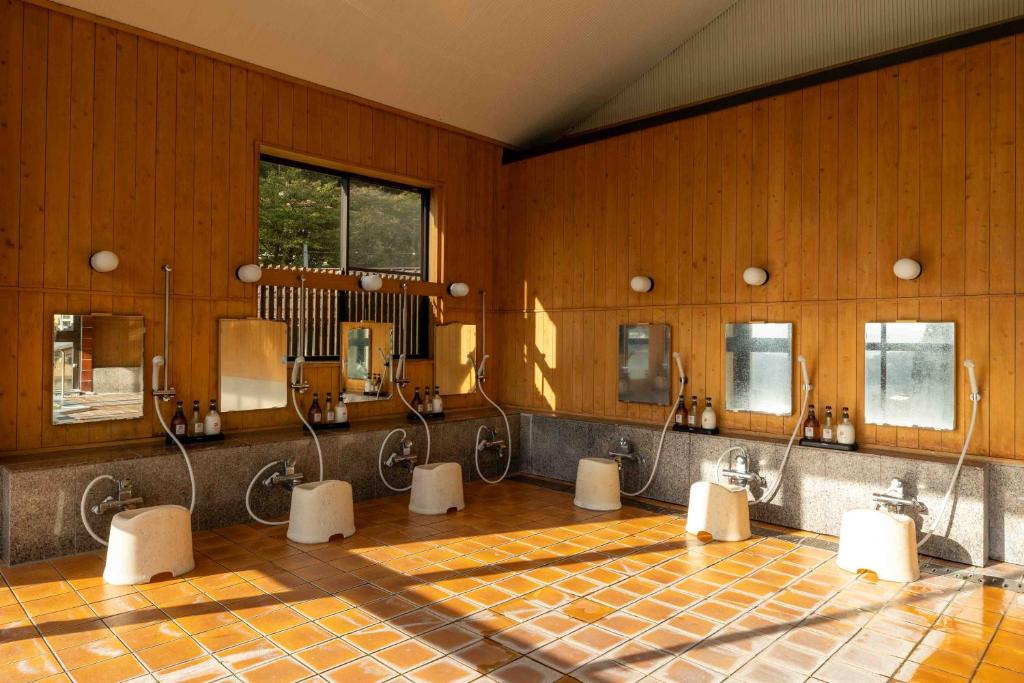 une salle de bain avec quatre lavabos et miroirs dans l'établissement Nozawa View Hotel Shimataya, à Nozawa Onsen 37 autres photos