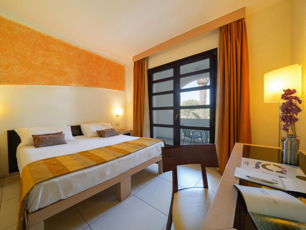 une chambre d'hôtel avec un lit, un bureau et une fenêtre dans l'établissement GH Gallipoli Resort, à Gallipoli
