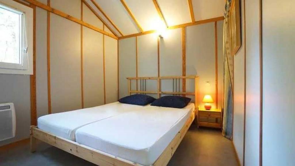 une chambre avec un grand lit dans une pièce dans l'établissement Camping 3 étoiles - Piscine - ccaideg, à Reyrevignes