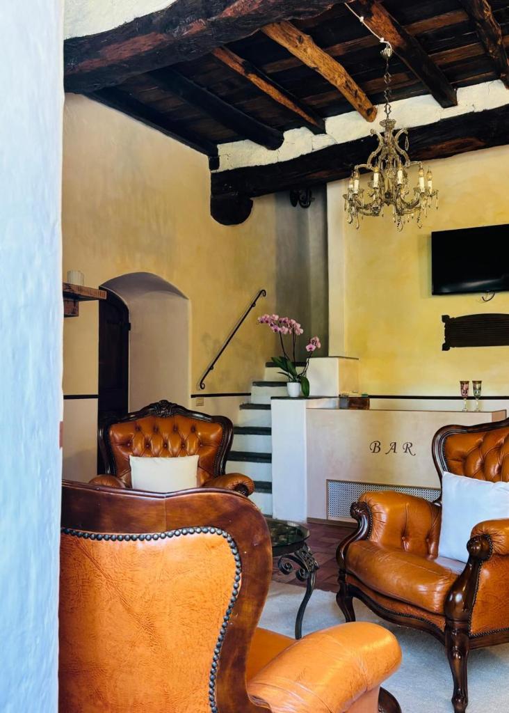 - un salon avec des fauteuils en cuir et un lustre dans l'établissement Torre Collevento Luxury Villa, à Orvieto