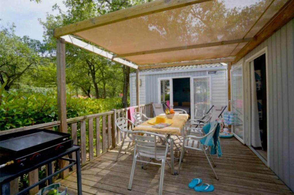 une terrasse avec une table, des chaises et un grill dans l'établissement Camping - Piscine - ccai0bg, à Argelès-sur-Mer