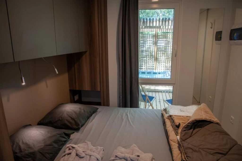 - une petite chambre avec un lit et une fenêtre dans l'établissement Camping 4 étoiles - Piscine - ccaffbg, à Villeneuve-lès-Béziers