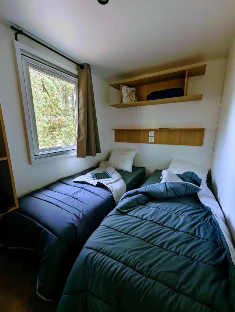 deux lits dans une petite pièce avec une fenêtre dans l'établissement Camping 3 étoiles - Piscine - ccb0ffa, à Fabrezan